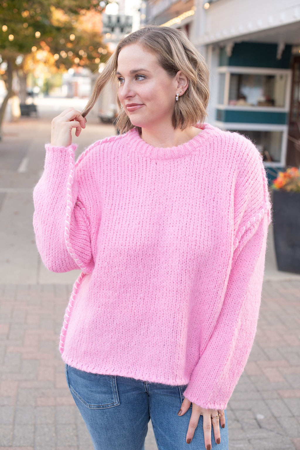 Woman wearing a pink sweater on a street